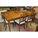 An Edwardian mahogany wind out dining table with one extra leaf^ raised on tapering square legs^