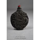 A Chinese pierced snuff bottle with red hardstone finial.