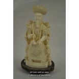 A resin figure of a Chinese dignitary on a throne, wooden stand, 22cm.