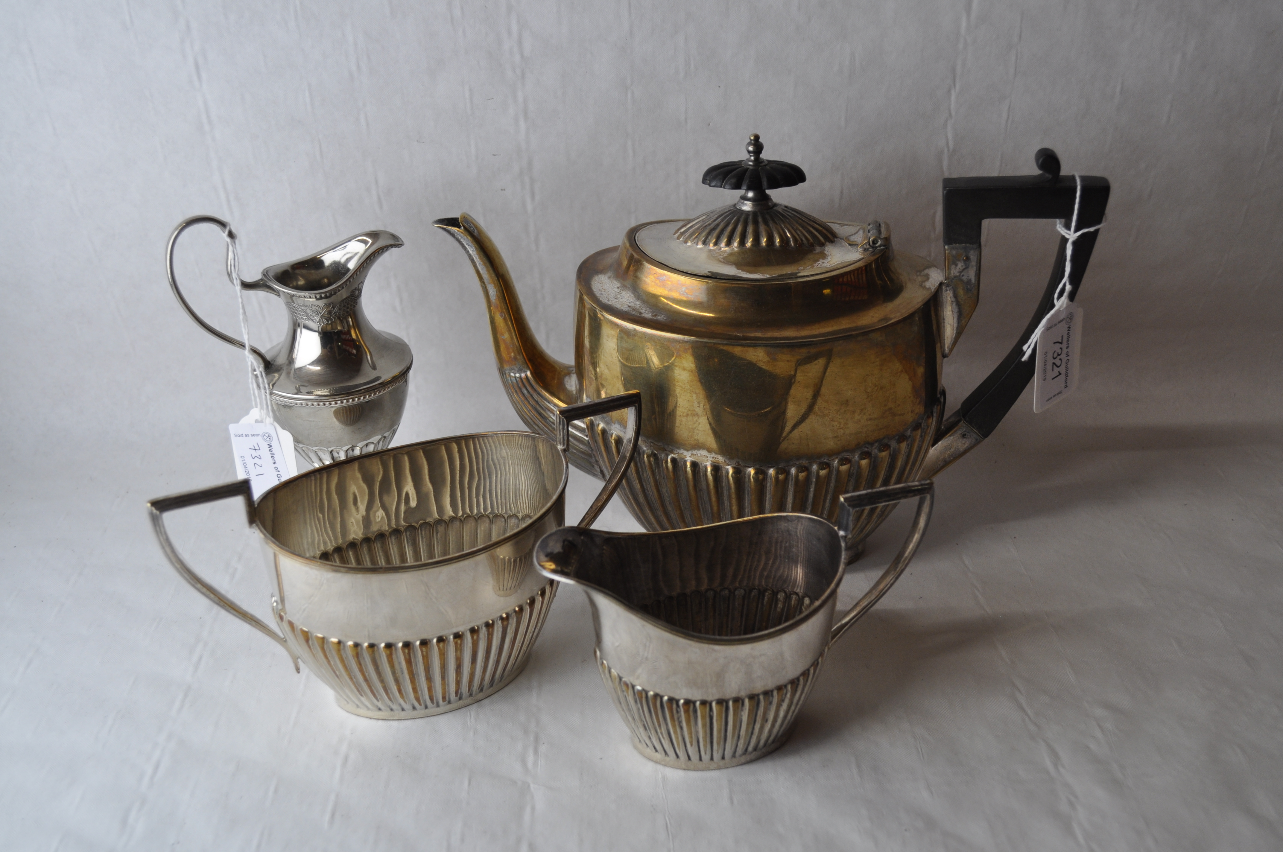 A three piece silver plated tea set and a similar cream jug.