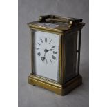 A brass carriage clock ^ the white enamel dial with Roman numerals^ 10.75cm excluding handle.