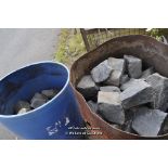TWO METAL OIL DRUMS CONTAINING BLACK COBBLE SETTS