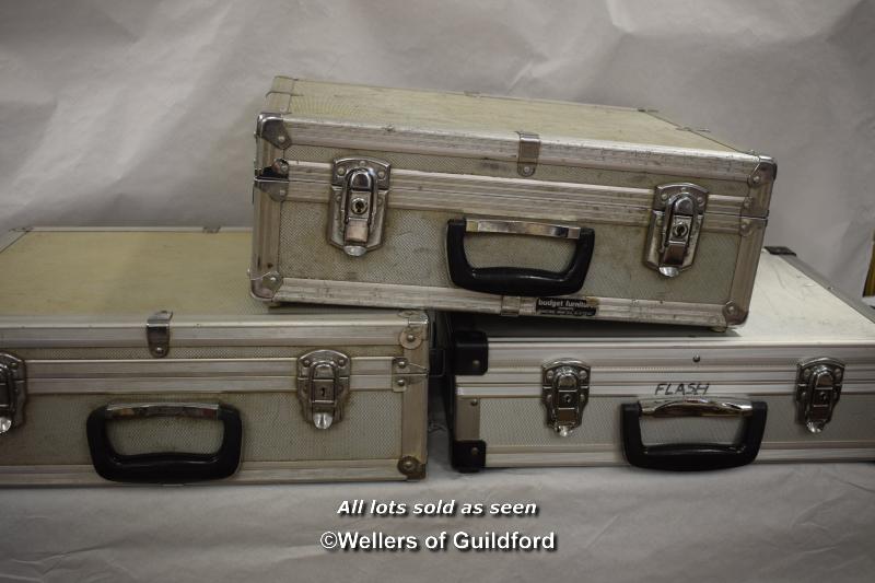 Three metal photographic equipment cases