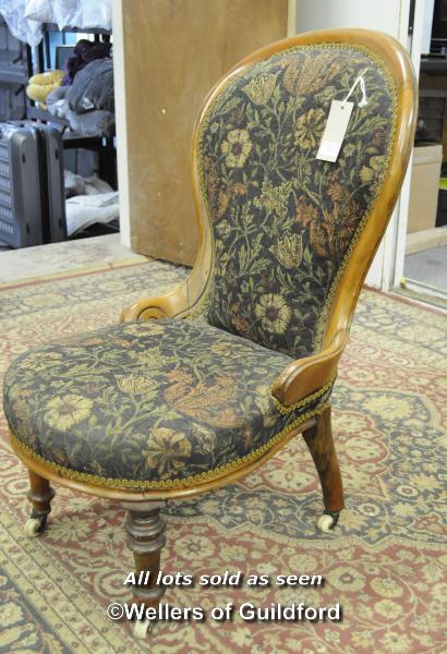 A Victorian walnut spoonback nursing chair on turned front legs.