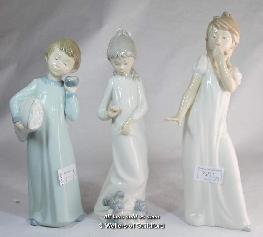 Three Nao figurines of children dressed in night clothes, the tallest 29cm.