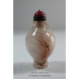 A Chinese pink stone snuff bottle with red stone finial.