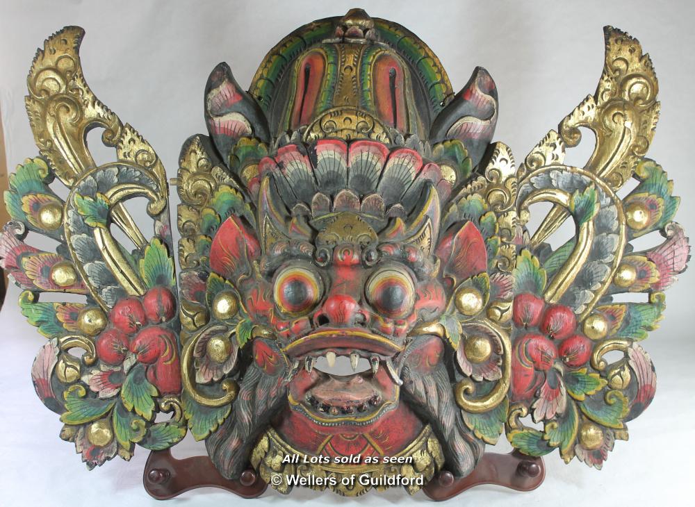 A large Balinese mask carved as a mythical beast.