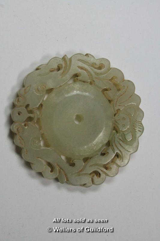 A Chinese carved hardstone pierced circular pendant, 5.5cm diameter.