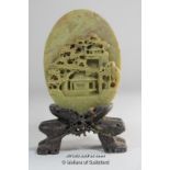 A Chinese carved hardstone oval panel depicting a village scene, with separate hardstone stand,