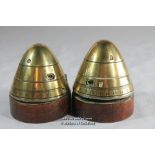 A pair of trench art paperwweights modelled from brass shell heads, with additional wooden plinths.