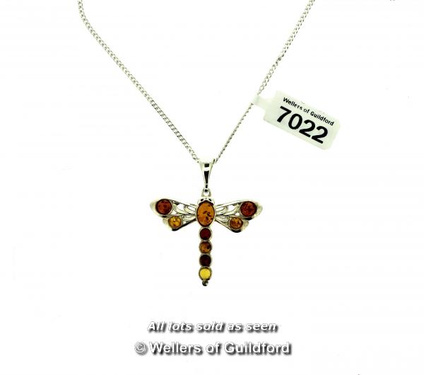 Amber dragonfly pendant, mounted in white metal tested as silver, on a white metal chain stamped