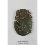 A Chinese green hardstone pendant carved as a dragon.