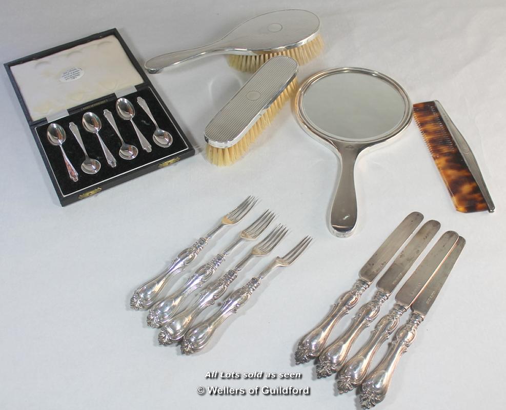 A silver four piece dressing table set comprising hand mirror, comb and two brushes, Birmingham