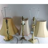 Three modern brass table lamps with shades.