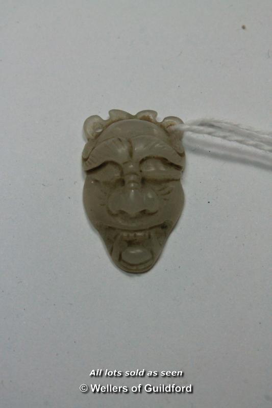A Chinese hardstone pendant carved as a face, 3cm.