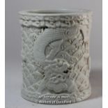 A Chinese cream cylindrical brush pot carved all over with dragons and scales, 12cm.