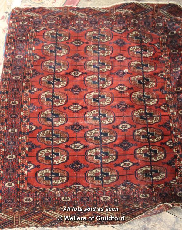 A small red Persian rug with three rows of medallions, 124 x 105cm.