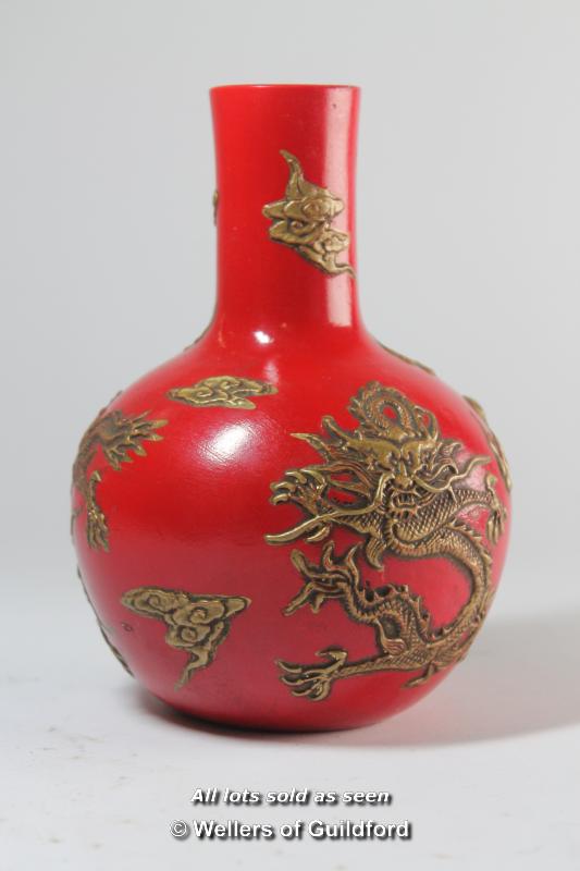 A Chinese globular pottery vase decorated in relief with dragons, 16cm.