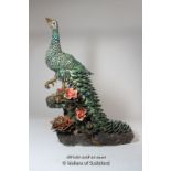 A Chinese peacock figurine decorated in rich green with trailing tail feathers, impressed marks to