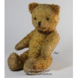 A small straw stuffed teddy bear with jointed arms and legs, stitched nose, m outh and claws, 30cm.