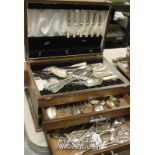 An oak cutlery canteen with lifting lid and two drawers, containing an assortment of silver plated