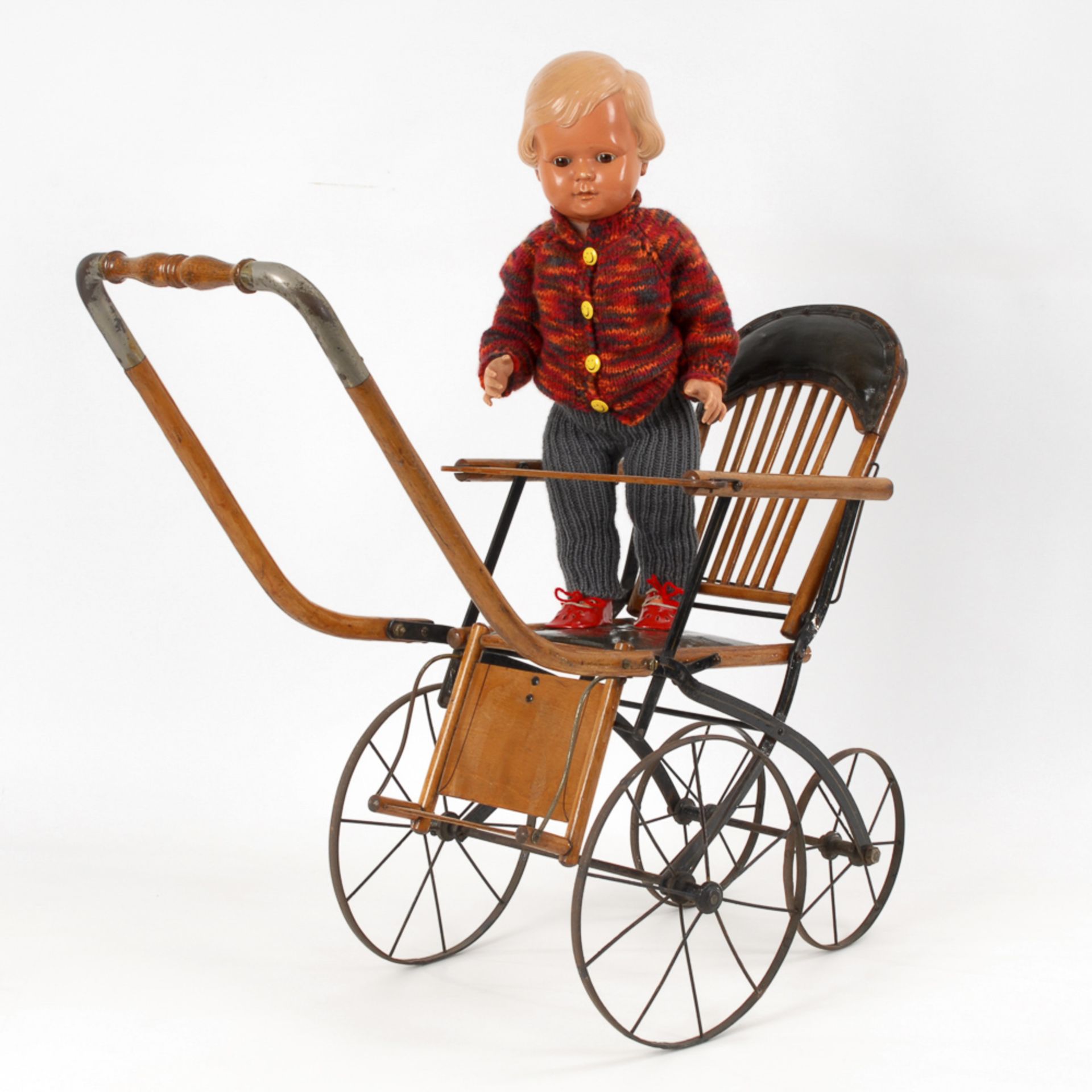 Puppenwagen mit Cellba-Puppe.1930er Jahre. Holz, Metall. H max. 63,5 cm, L der Puppe 50 cm.