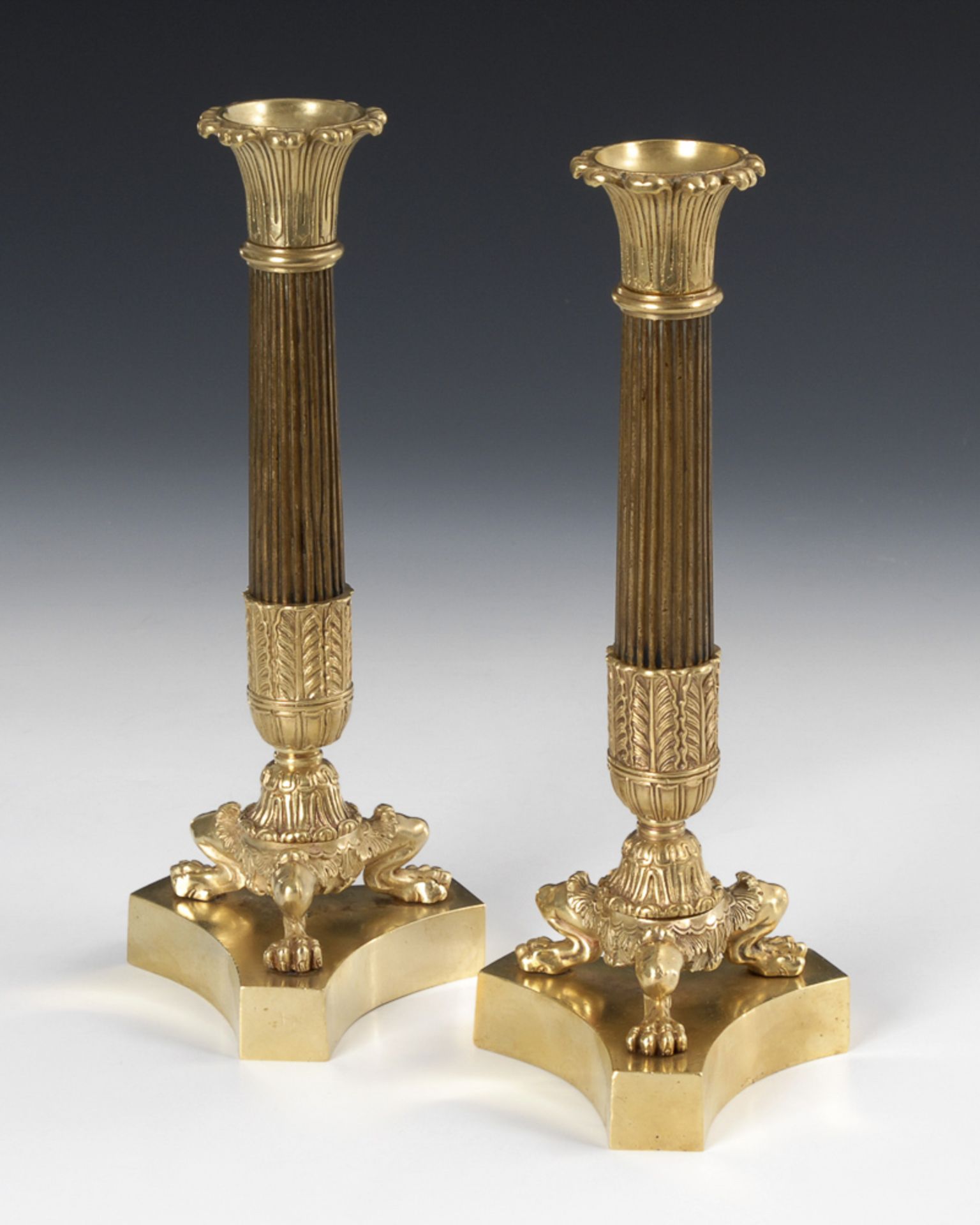 Paar Bronzeleuchter im Spätempire-Stil.Um 1840. Teils braun patiniert. H 28 cm. Auf 3-seitiger