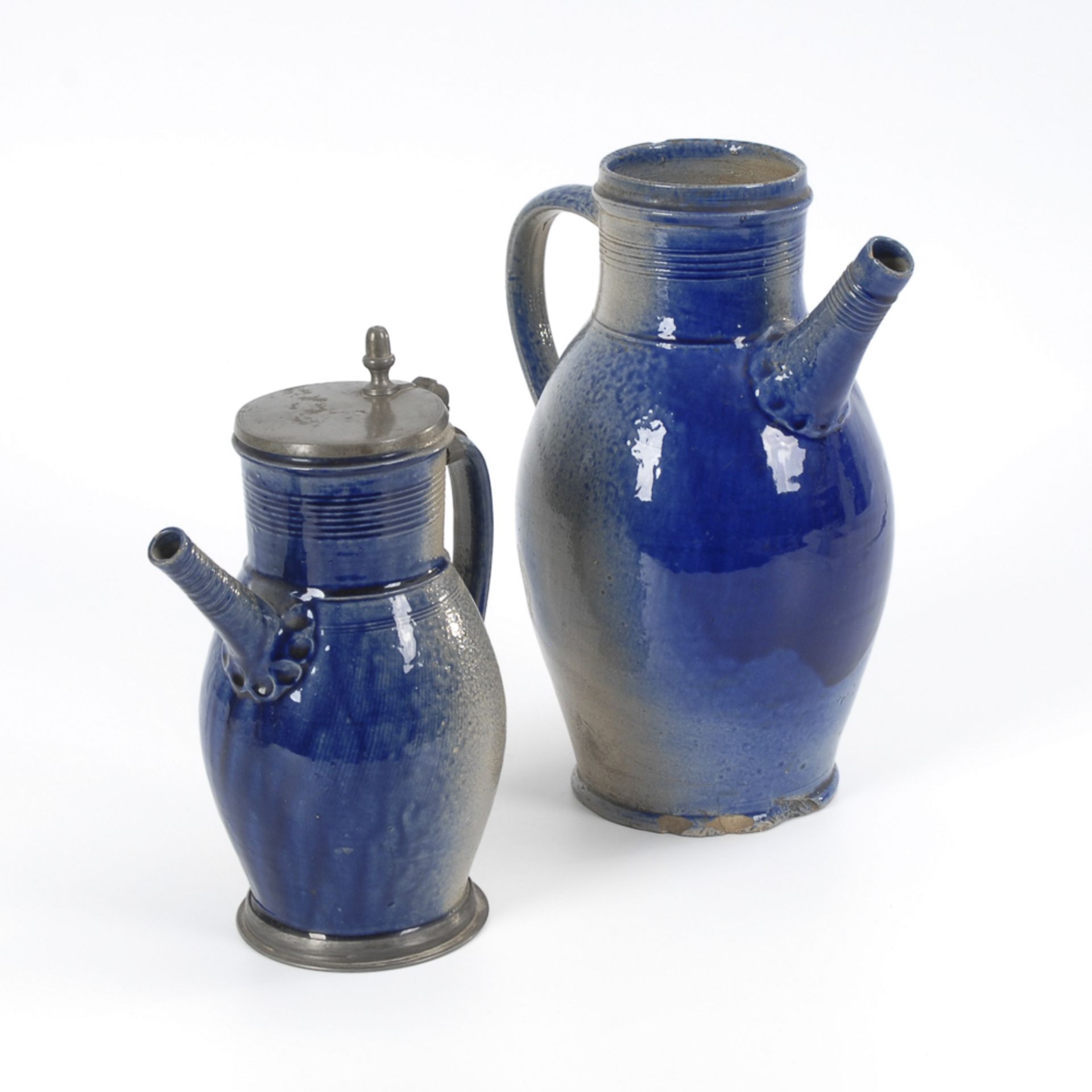 2 Tüllenkannen, BÜRGEL.Um 1800. Graues, salzglasiertes Steinzeug mit blauem Smaltebewurf. H 30,