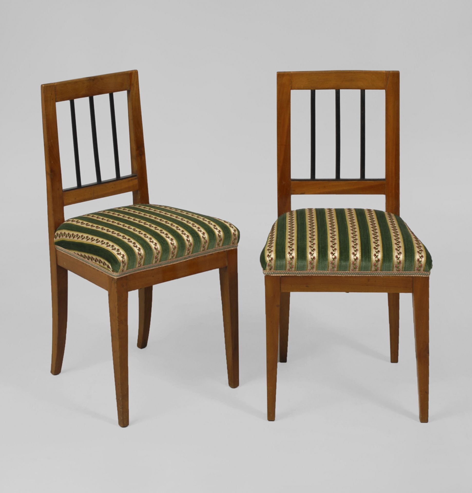 2 Biedermeier-Stühle.Um 1830. Kirschbaum furniert. H je 89 cm. 2 Polsterstühle mit 3-fach