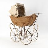 Korb-Puppenwagen mit hellem Verdeck.Um 1900. Korb, Eisen, Leder. 96 x 85 x 33 cm. Geflochtener Wagen