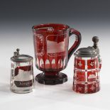 Henkelbecher und 2 Miniaturhumpen.Böhmen, 2. Hälfte 19. Jahrhundert. Farbloses, teils rot