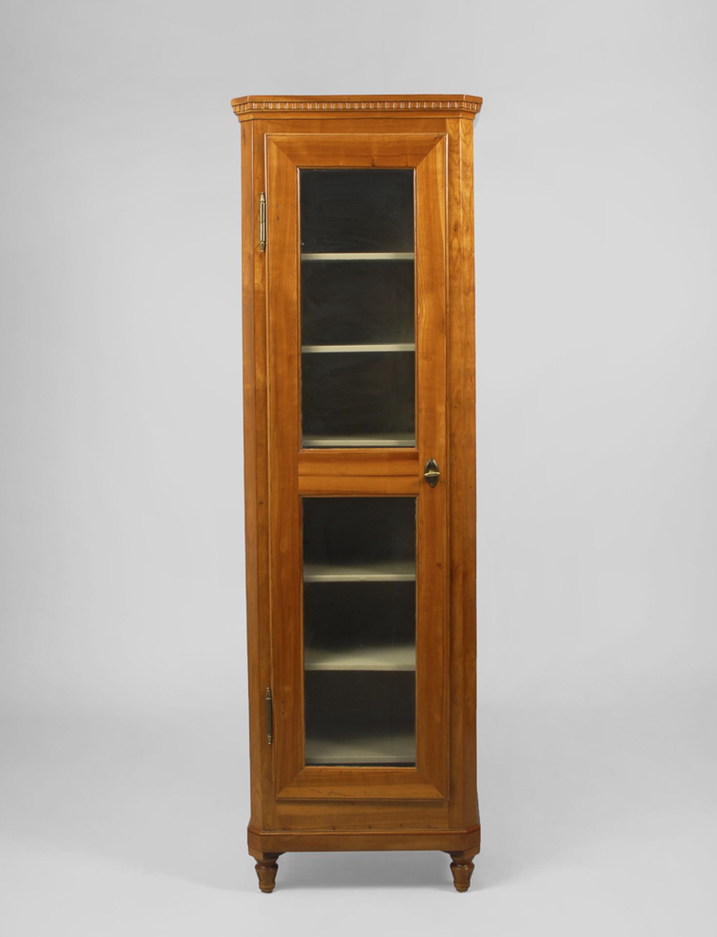 Biedermeier-Pfeiler-Vitrinenschrank.Um 1830/40. Kirschbaum furniert. 208 x 63 x 41 cm. Hohe