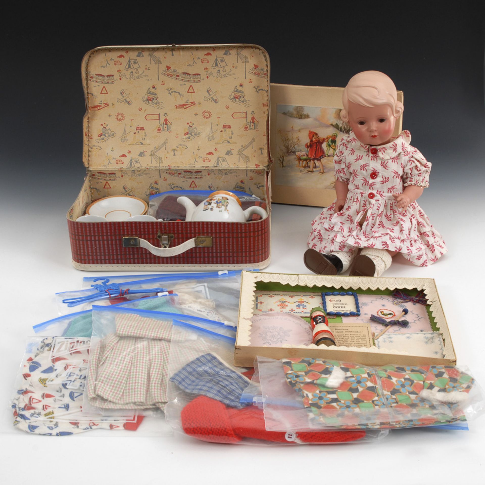 SCHILDKRÖT-"Inge", Koffer mit Puppenkleidung und Kasten mit Strickliesel.Celluloid, Holz, Pappe,