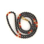 Halskette mit Hämamit und Koralle.585 GG, L 49 cm, 8,9 g. Schnürkette mit kleinen, schwarzen Stein-,