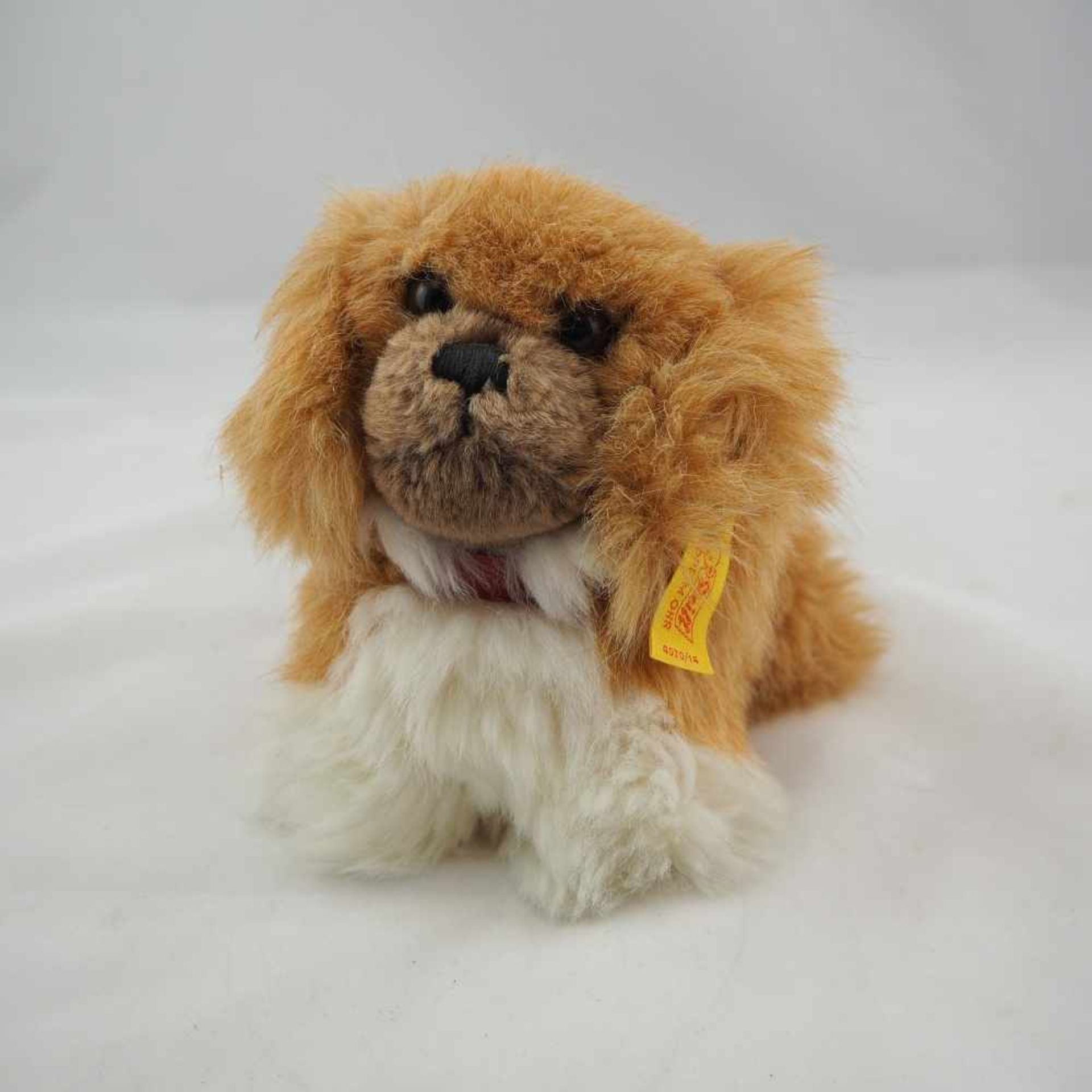 "Steiff" PekinesePekinese der Firma "Steiff", 1980-85. Gelbe Fahne mit Knopf im Ohr. L.22cm."Steiff"