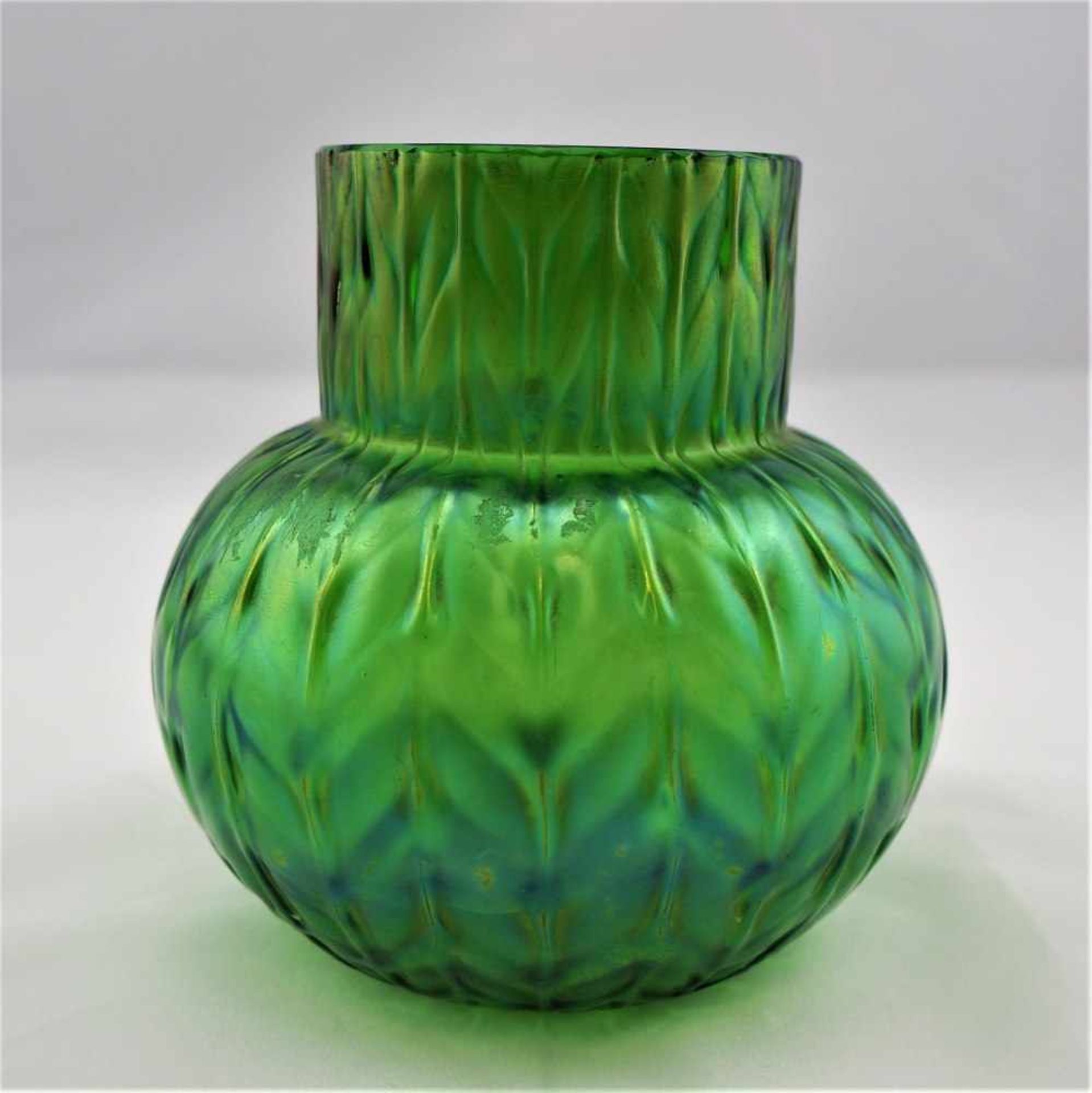 Kleine Vase, Loetz um 1920Grünes Glas, leicht irisierend, in Kürbisform. Mit Blattmotiv im Relief.