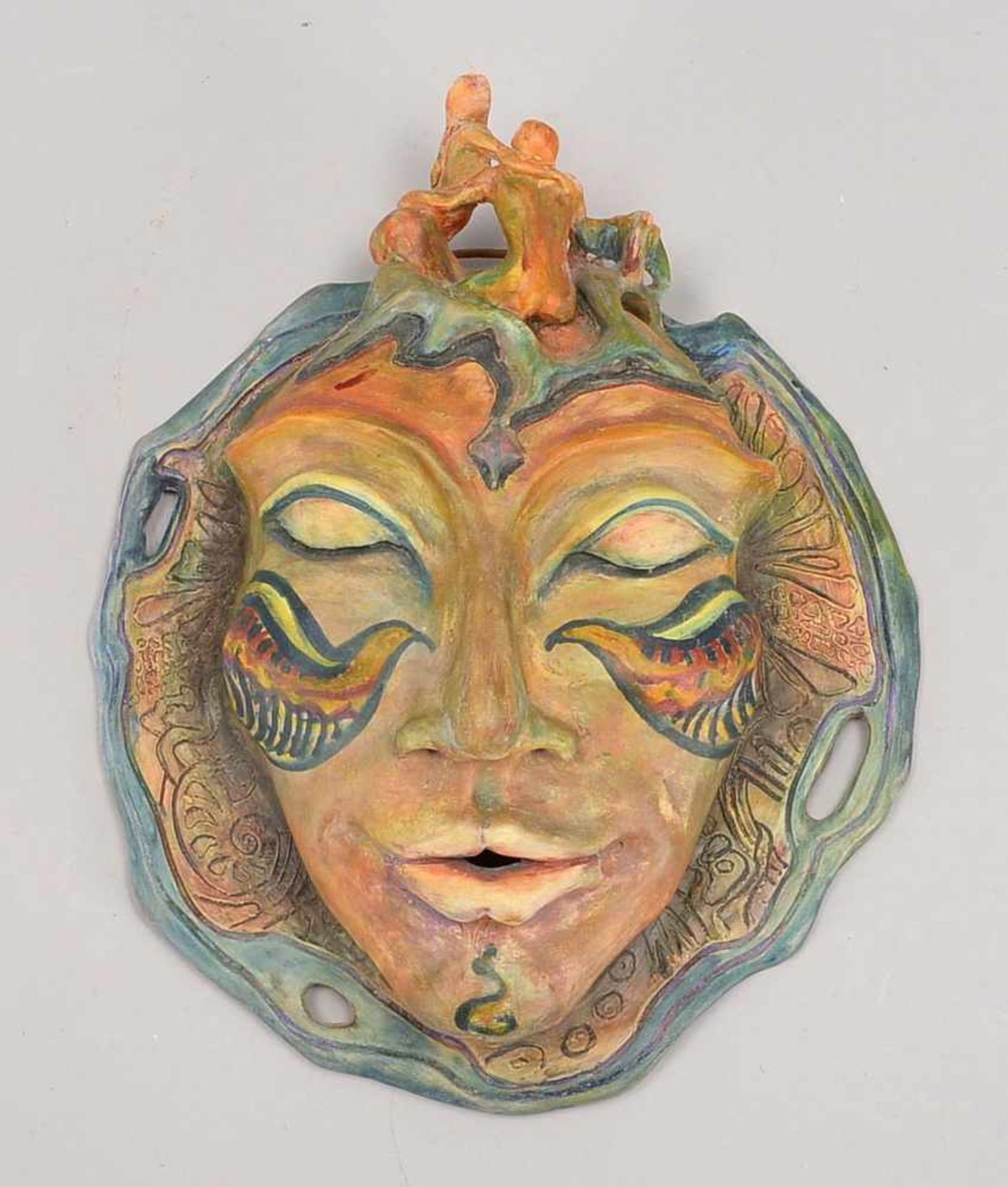 Wandmaske, Künstlerkeramik (wohl Unikat), polychromiert, mit figürlicher Bekrönung; Höhe 26 cm,