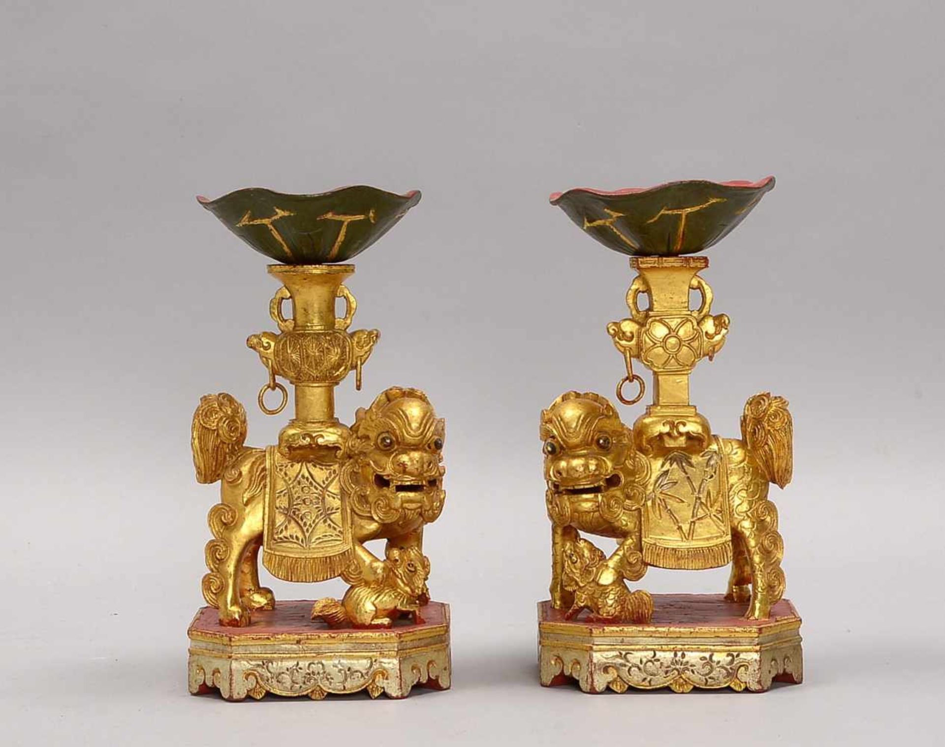 Paar 'Fu-Hunde', jeweils eine Vase tragend, Holz vergoldet/partiell mit Rotlack; Höhe 23 cm (
