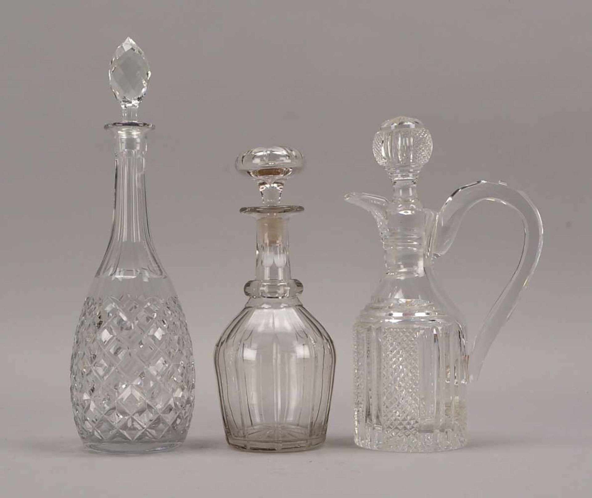 3 Karaffen, Bleikristall, fein beschliffen, jeweils mit eingeschliffenem Glasstopfen; Höhe 28,5 cm -