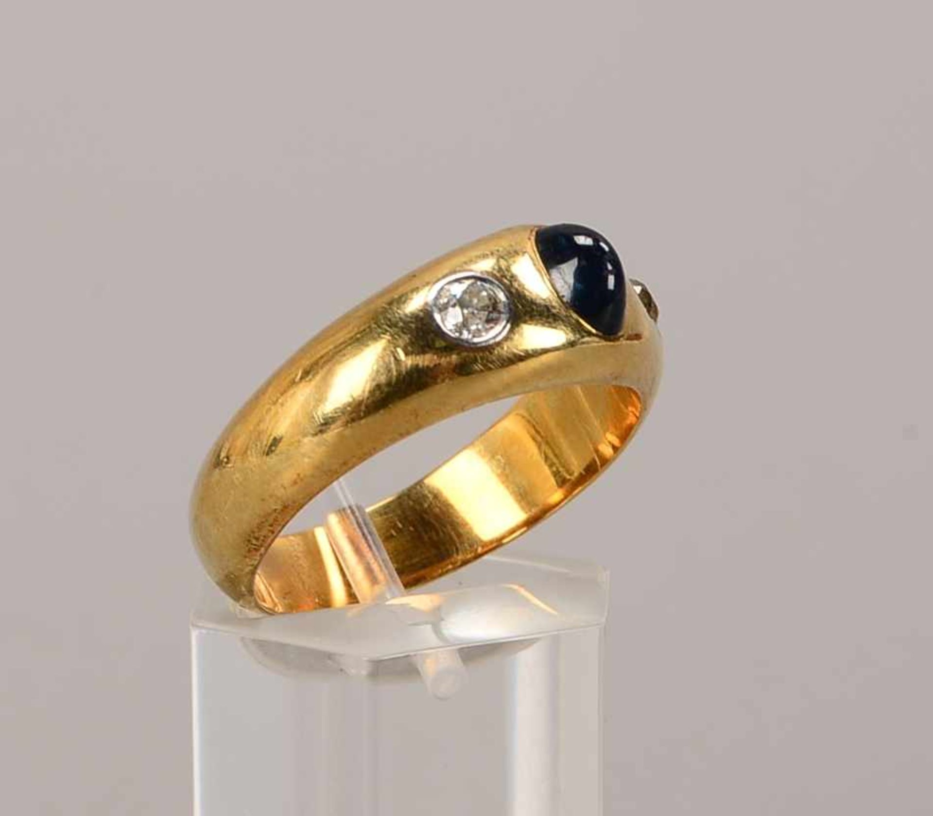 Ring, 585 GG, besetzt mit einzelnem Saphir-Cabochon, und mit 2-fachem Diamantbesatz/zusammen ca. 0,