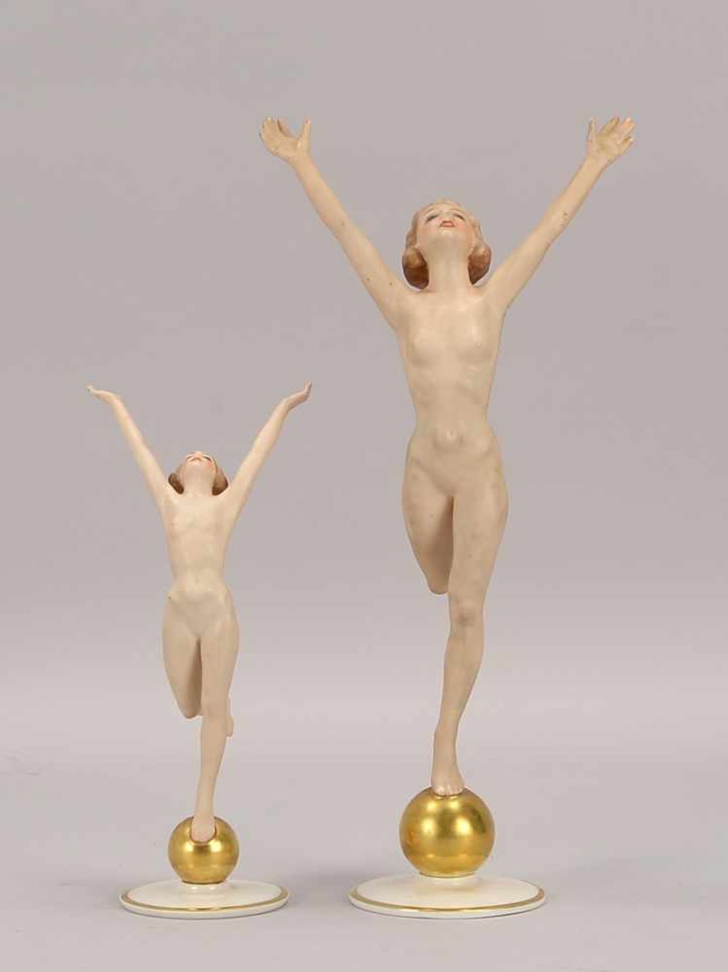 Hutschenreuther/Kunstabteilung, 2 Porzellanfiguren 'Sonnenkind' (weibliche Akte auf Goldkugel