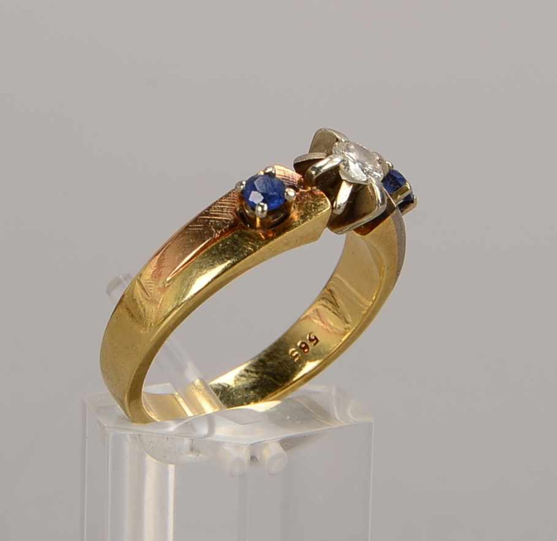 Ring, 585 GG, besetzt mit einzelnem Brillant von ca. 0,2 ct, Farbe Weiß/Si, flankiert von 2x