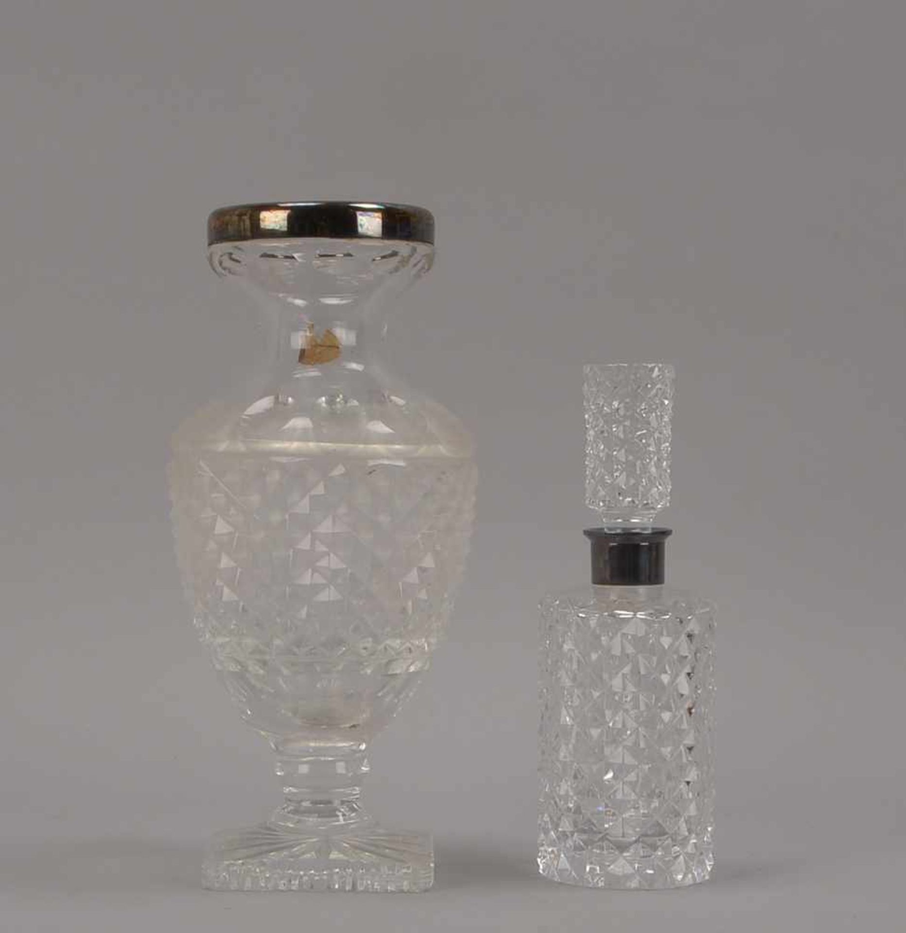 2 Glasgefäße, Kristallglas geschliffen, mit Silber-Montierung: 1 Karaffe und 1 Vase; Höhe 22 cm, und