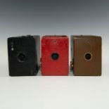 TRIO OF MULTICOLORED ANTIQUE KODAK BOX CAMERAS