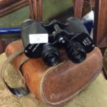 A pair of binoculars in leather case.