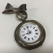 A small silver open faced fob watch with engraved