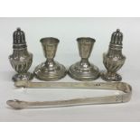 A pair of pepperettes together with candlesticks a
