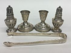 A pair of pepperettes together with candlesticks a