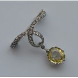 A large diamond and yellow sapphire brooch in claw