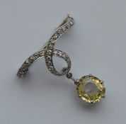 A large diamond and yellow sapphire brooch in claw